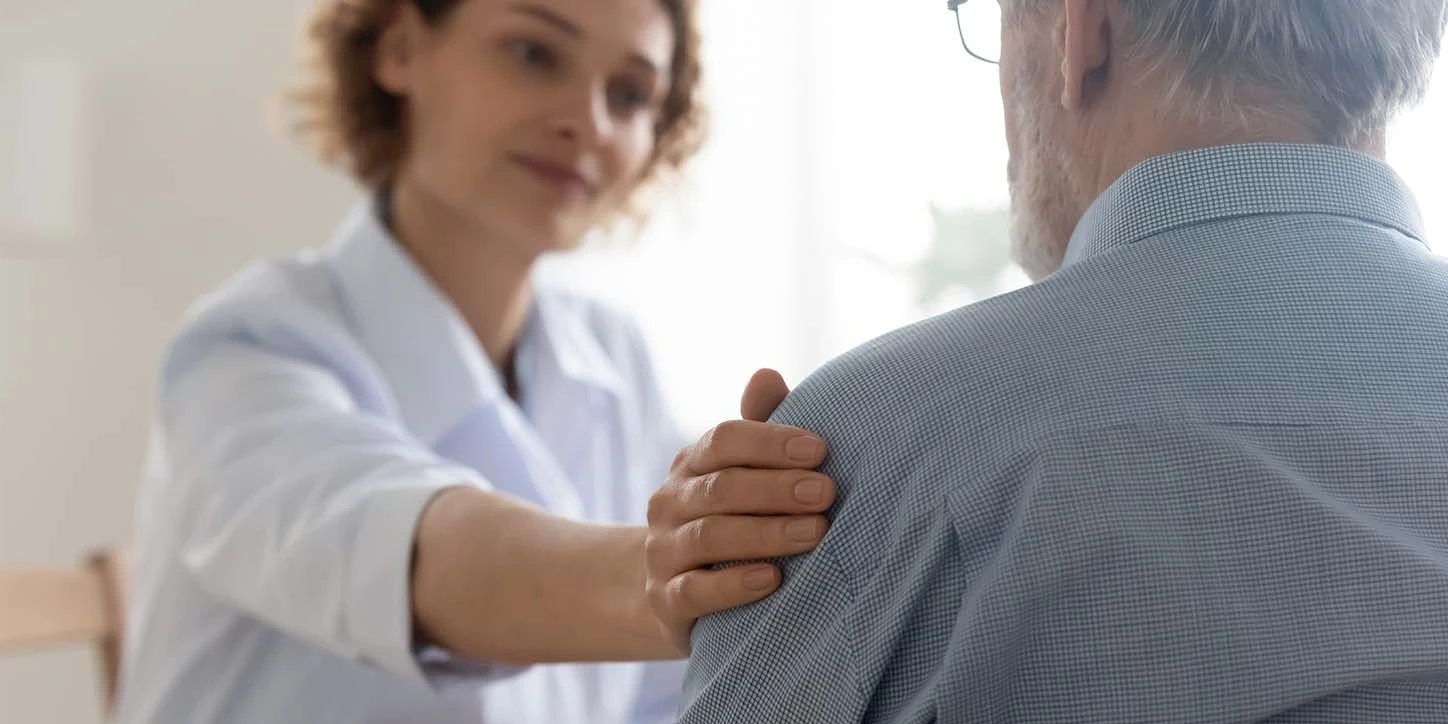 Homem de meia idade discutindo sobre parkinson e saúde mental com a psicóloga