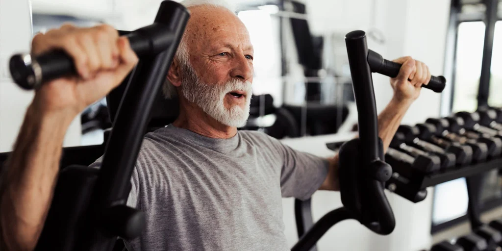 senhor fazendo exercícios em aparelho da academia mostrando que o exercício físico ajuda no controle do Parkinson