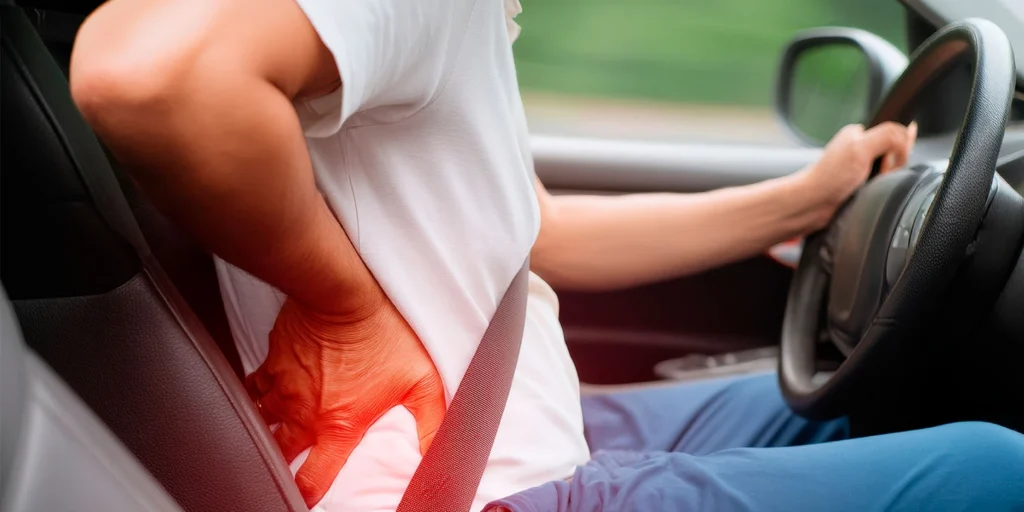 Homem dirigindo e sentindo dores nas costas, a radiofrequência pode ser uma soução pra ele.