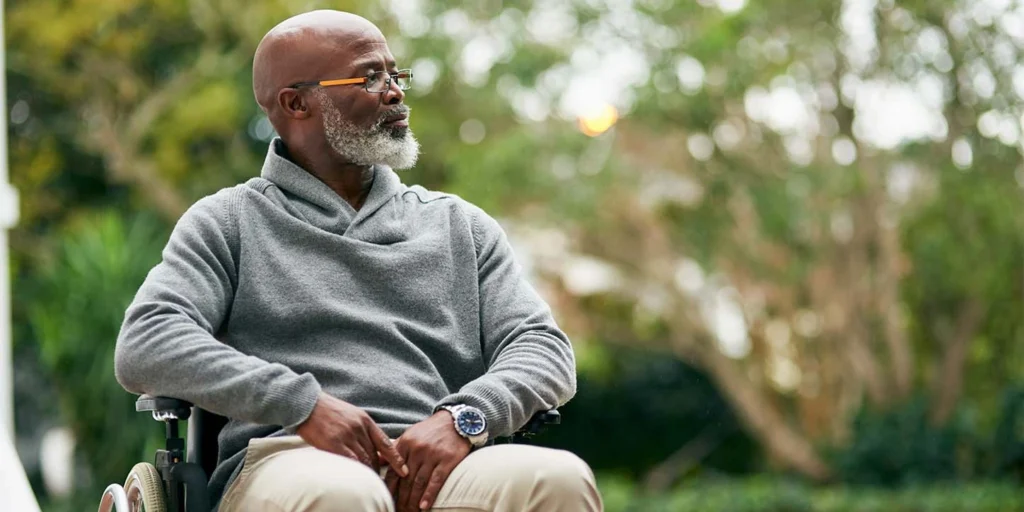 Médica neurologista conversando e explicando informações em um tablet para um paciente idoso e sorridente durante uma consulta sobre Paralisia Supranuclear Progressiva