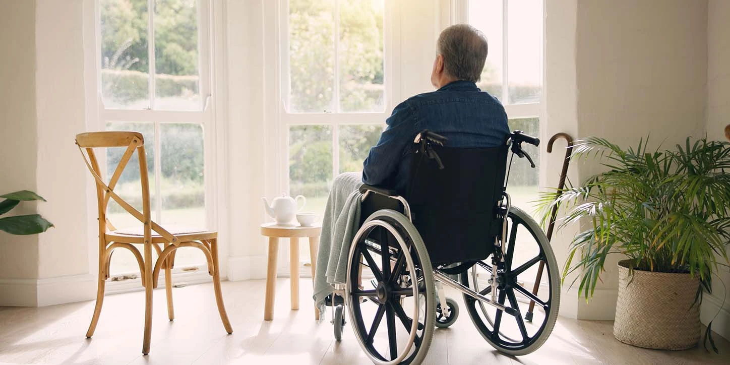 Homem em cadeira de rodas, de costas, ilustrando os desafios de mobilidade enfrentados por pessoas com Atrofia de Múltiplos Sistemas (MSA).