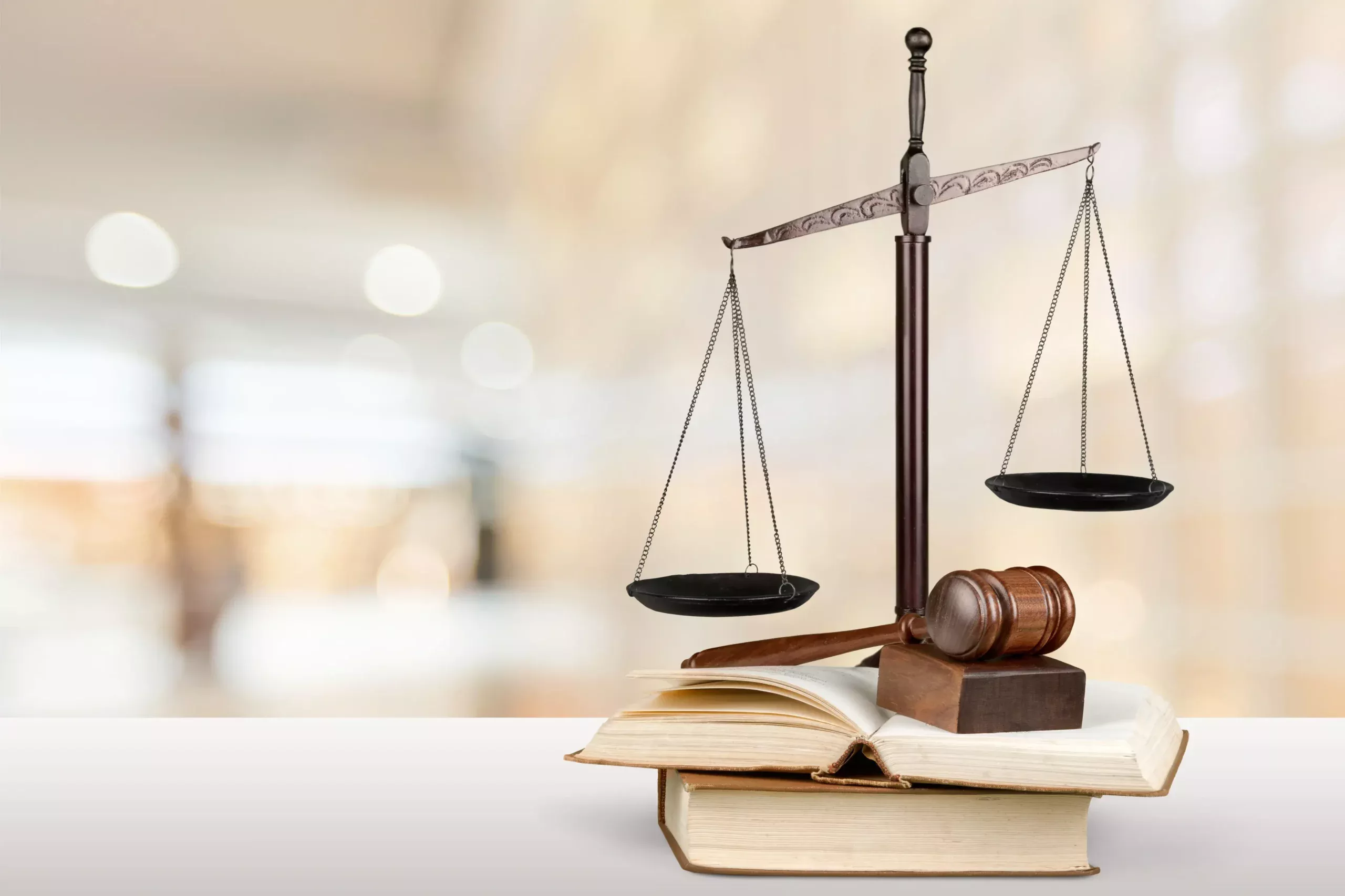 Balança de duas pratas e martelo da justiça sobre livros jurídicos, representando o suporte legal e os direitos do paciente com Parkinson.